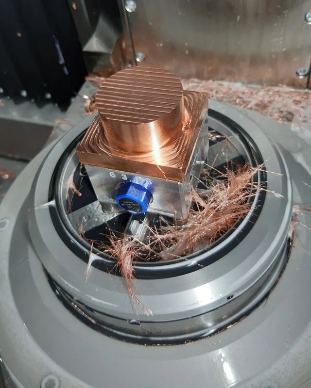 Electrodo de cobre recién fresado, sujeto en la máquina entre virutas de cobre